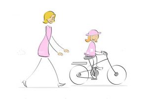 Mother running behind girl cycling